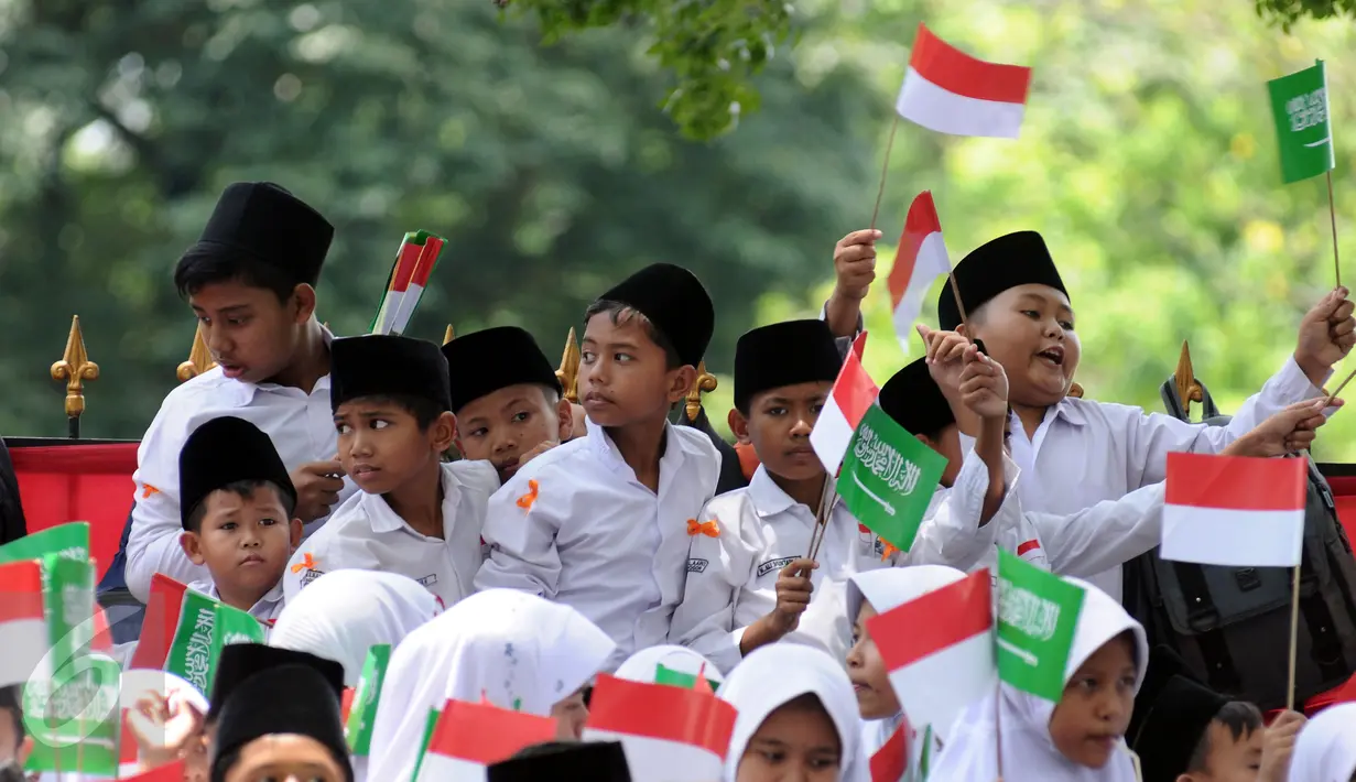 Sejumlah pelajar mengibarkan bendera kedua negara untuk menyambut kedatangan Raja Salman bin Abdulaziz di sekitar Istana Bogor, Rabu (1/3). 21 dentuman meriam dan kibaran bendera kedua negara mewarnai sambut Raja Salman. (Liputan6.com/Helmi Fithriansyah)