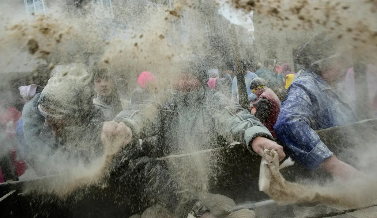 Sejumlah peserta saling melempar tepung saat mengikuti festival "Domingo Fareleiro" di desa Xinzo de Limia, Spanyol (21/1). Festival ini juga merupakan ritual pemurnian menjelang masa prapaskah. (AFP/Miguel Riopa)