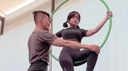 Tak sendirian, Fuji juga didampingi trainer saat latihan aerial hoop. Meski terlihat mudah, gerakan aerial hoop seperti yang dilakukan pemain film Bukan Cinderella ini mengerahkan banyak tenaga. (Liputan6.com/IG/@fuji_an)