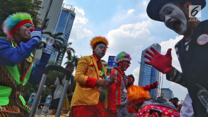 Komunitas Aku Badut Indonesia menggelar aksi penggalangan dana saat Car Free Day (CFD) di kawasan Thamrin, Jakarta, Minggu (6/1). Mereka melakukan atraksi akrobatik untuk menggalang dana bagi korban bencana tsunami Selat Sunda. (Liputan6.com/Johan Tallo)