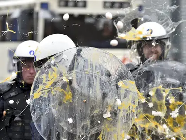 Polisi dilempari telur oleh peternak dan petani yang melakukan aksi protes saat pertemuan Menteri-menteri Eropoa di Brussels, Belgia, 7 September 2015. Aksi tersebut menuntut bantuan harga murah dan biaya yang tinggi. (REUTERS/Eric Vidal)