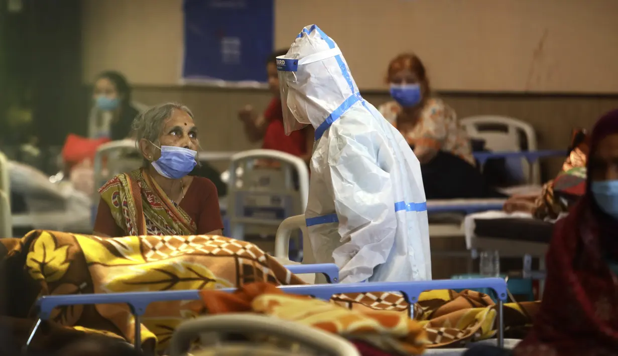 Petugas kesehatan berbicara dengan seorang wanita di pusat karantina untuk pasien COVID-19 di New Delhi, India, Senin (19/4/2021). Pihak berwenang mengatakan pada hari Senin bahwa rumah sakit telah didorong hingga batasnya. (AP Photo/Manish Swarup)