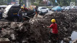 Pekerja membongkar saluran air (drainase) yang akan diperbaiki di jalan Hayam Wuruk, Jakarta Pusat, Selasa (20/11). Perbaikan dan pelebaran saluran air ini untuk mengantisipasi terjadinya banjir di kawasan tersebut saat hujan. (Liputan6.com/Johan Tallo)