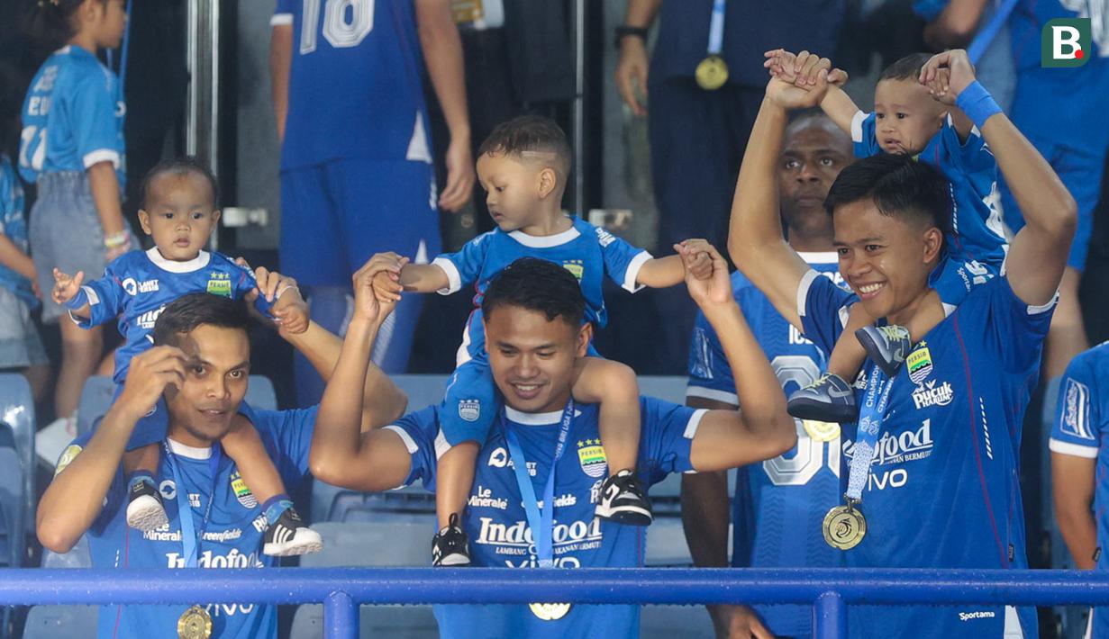 Pemain Persib Bandung menggendong anaknya saat pesta juara BRI Liga 1 2024/2025 di Stadion Gelora Bandung Lautan Api, Sabtu (24/5/2025) sore WIB. (Bola.com/M Iqbal Ichsan)