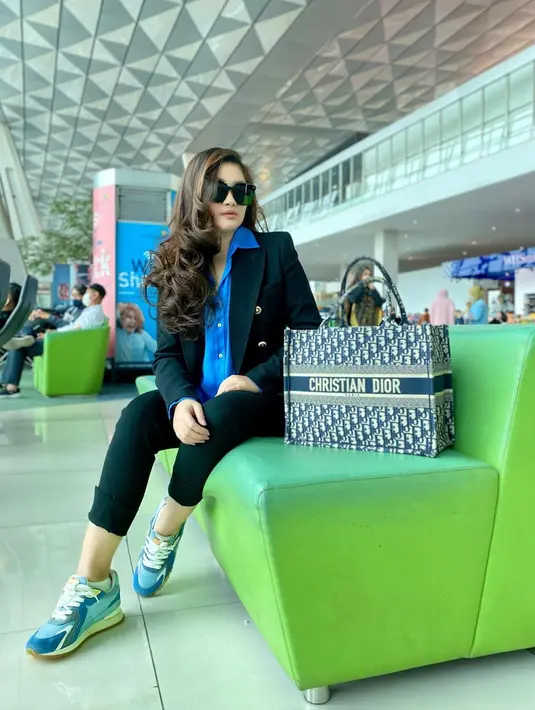 OOTD kece lainnya dari Fitri Carlina saat ia di bandara. Ia tampil elegan mengenakan kemeja biru ditumpuknya dengan blazer hitam dan celana panjang hitam. Ia semakin tampak keren dengan padu padan sneakers bernuansa biru dan memakai sunglasses. [Foto: Instagram/fitricarlina]