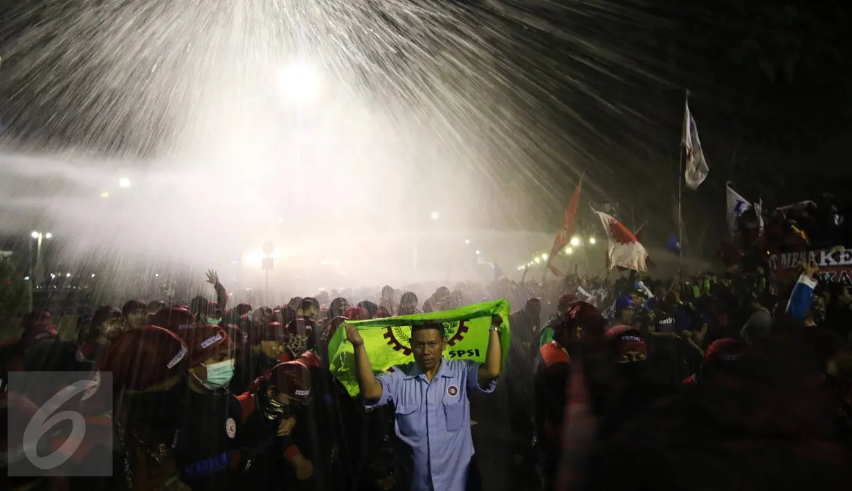 Tembakan Water Cannon membubarpaksakan aksi buruh di depan Istana Merdeka, Jakarta, Jumat (30/10/2015). Polisi terpaksa menembakkan gas air mata karena aksi sudah melewati batas waktu yang disepakati. (Liputan6.com/Immanuel Antonius)