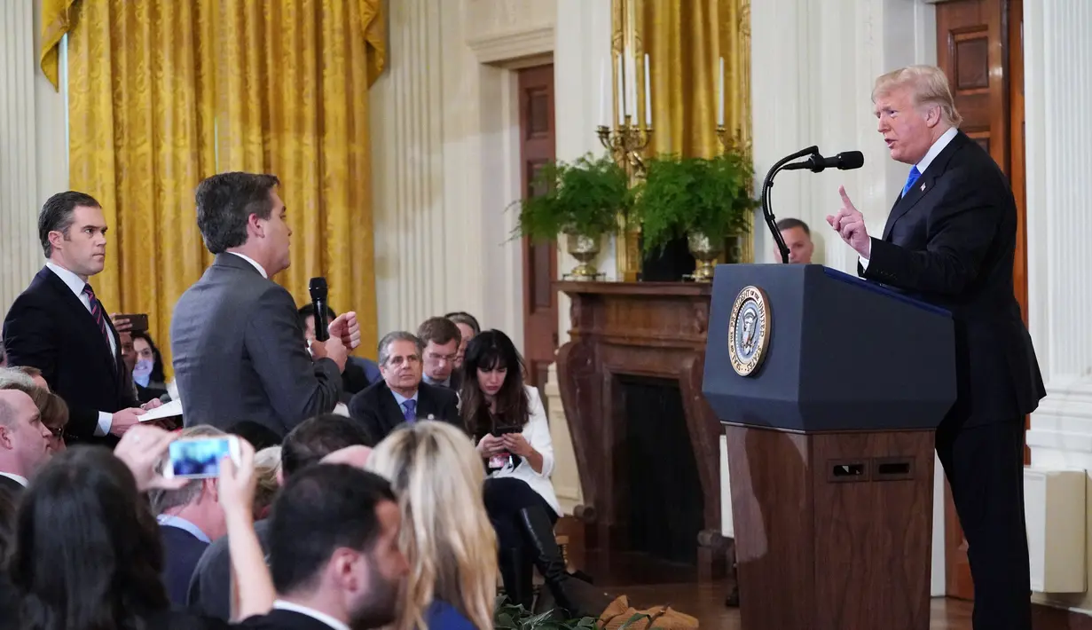 Presiden AS, Donald Trump terlibat adu mulut dengan jurnalis CNN, Jim Acosta (tengah) saat konferensi pers di Gedung Putih sesaat setelah pemilu sela digelar, Rabu (7/11). Ketegangan bermula dari pertanyaan sang wartawan soal imigran. (MANDEL NGAN/AFP)