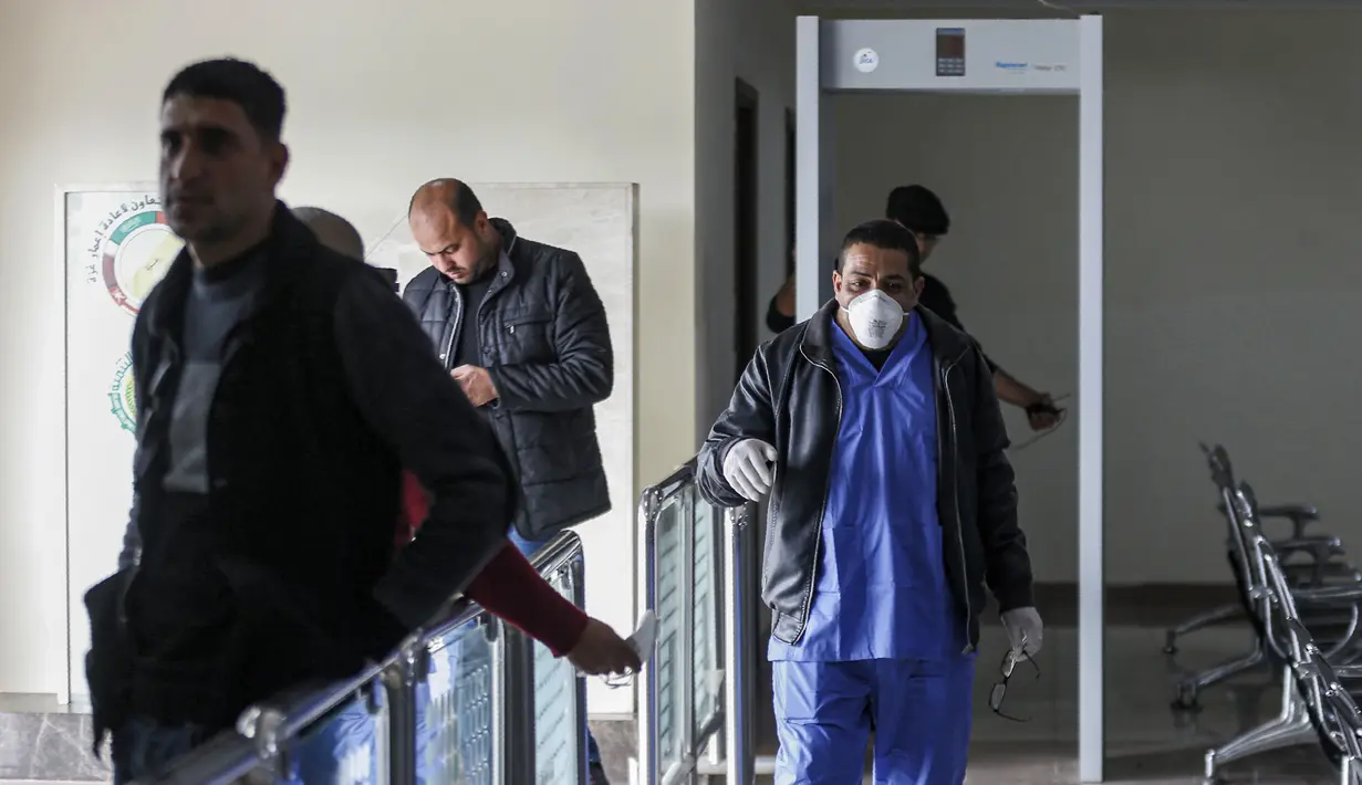 Petugas kesehatan berjalan di zona karantina perbatasan Rafah dengan Mesir di Jalur Gaza, Palestina, Minggu (16/2/2020). Kementerian Kesehatan Palestina membangun zona karantina sebagai upaya untuk mengantisipasi wabah virus corona atau COVID-19. (SAID KHATIB/AFP)