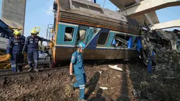 Pemerintah setempat melaporkan sedikitnya 22 orang tewas. Puluhan orang dilaporkan terluka dan tim penyelamat telah dikerahkan untuk membebaskan mereka yang terjebak di dalam gerbong kereta. Tampak dalam foto, tim penyelamat bekerja di tengah reruntuhan setelah sebuah crane atau derek konstruksi jatuh menimpa kereta penumpang di provinsi Nakhon Ratchasima, Thailand, Rabu 14 Januari 2026. (AP Photo/Sakchai Lalit)