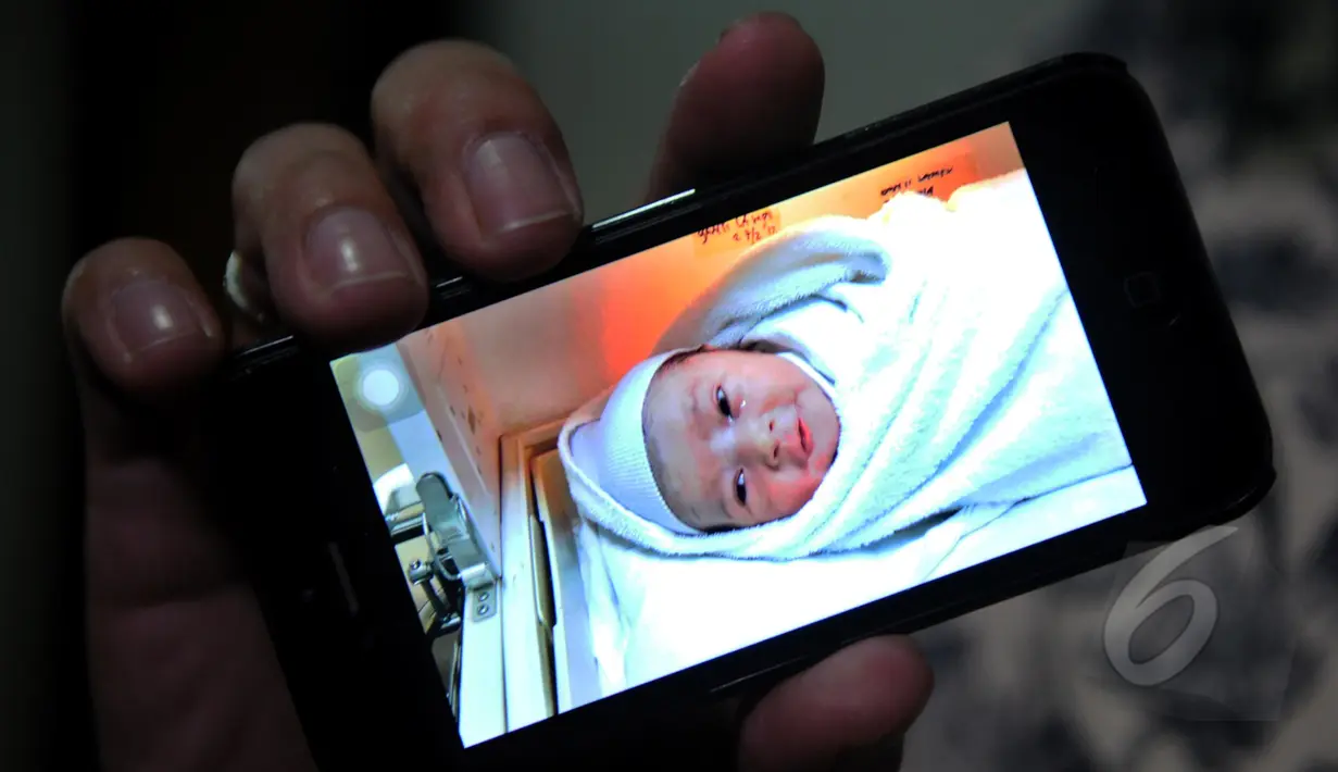 Vokalis Ada Band, Donnie Sibarani saat menunjukan foto bayi laki-lakinya yang lahir pada 18 April lalu di RS Bersalin Asih dan diberi nama Kent Leopold Sibarani, Jakarta, Selasa (21/4/2015). (Liputan6.com/Faisal R Syam)