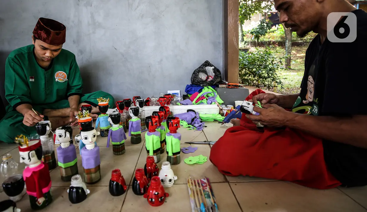 Chairuddin (40) bersama rekannya menyelesaikan pembuatan ondel-ondel dari botol bekas di Sanggar Rumah Kreasi, Jakarta, Minggu (13/6/2021). Botol bekas dimanfaatkan menjadi ondel-ondel untuk dijual dengan harga sepasang Rp35 ribu dan bisa membuat ratusan setiap harinya. (Liputan6.com/Johan Tallo)