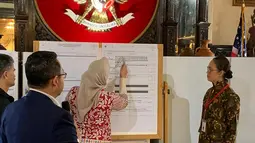 Petugas KPPS Luar Negeri mencatat perolehan suara saat penghitungan suara Pemilu 2019 yang dikirimkan melalui pos maupun yang dicoblos langsung di TPS oleh pemilih WNI, di KBRI Washington DC, Kamis (18/4). Jokowi meraih 1113, sementara pasangan Prabowo-Sandi meraih 352 suara. (Liputan6.com/HO/Butet)