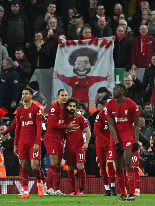 Pemain Liverpool, Mohamed Salah (tengah) melakukan selebrasi bersama rekannya setelah mencetak gol keempat tim ke gawang Manchester United pada laga pekan ke-26 Liga Inggris 2022/2023 yang berlangsung di Anfield, Liverpool, Senin (06/03/2023) WIB. (AFP/Paul Ellis)