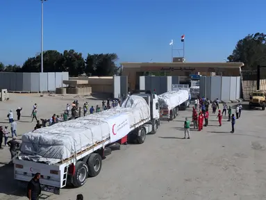 Orang-orang di perbatasan Rafah sisi Mesir bersorak saat konvoi truk yang membawa bantuan kemanusiaan melintasi Jalur Gaza, Sabtu (21/10/2023). (Mohammed Assad / AFP)