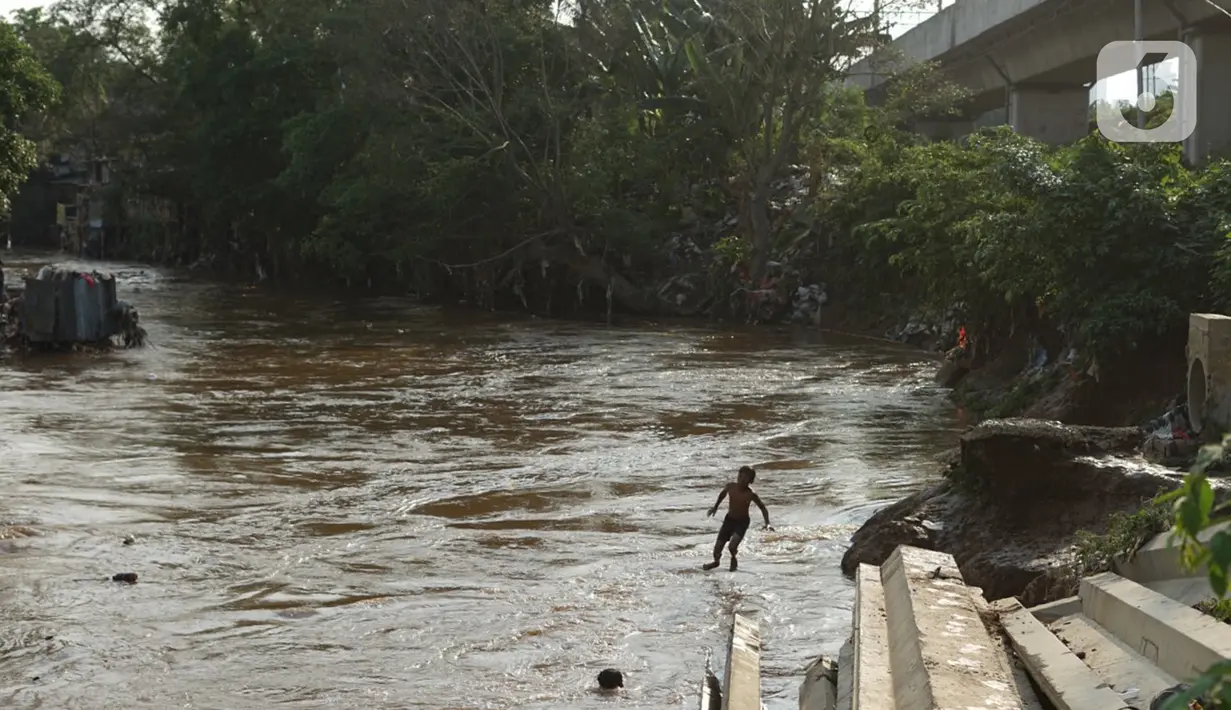 Anak-anak berenang di bantaran Sungai Ciliwung, Jakarta, Senin (5/10/2020). Derasnya aliran Sungai Ciliwung akibat hujan deras yang mengguyur Jakarta tidak menyurutkan kemauan anak-anak tersebut untuk tetap berenang, meski dapat membahayakan keselamatan mereka. (Liputan6.com/Immanuel Antonius)