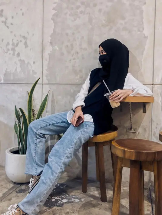 Gaya edgy diciptakan Adiba melalui vest dan kemeja putih. Bawahannya ia pilih straight leg jeans dan sneakers.  [Instagram/adiba.knza]