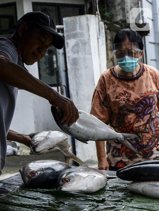 Pedagang ikan bandeng melayani pembeli di kawasan Rawa Belong, Jakarta Barat, Rabu (10/2/2021). Ikan bandeng dipatok dengan harga sekitar Rp 75.000 per kilogram dari yang terkecil hingga terbesar. (Liputan6.com/Johan Tallo)