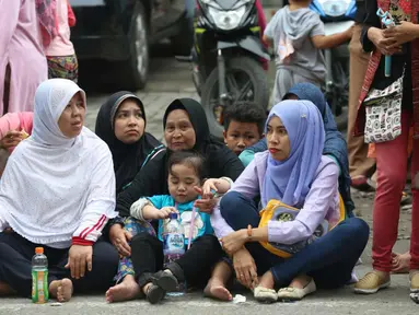 Warga duduk di jalan jelang kirab atau arak-arakan acara resepsi Kahiyang Ayu Siregar-Bobby Nasution di Kota Medan, Sumatera Utara Minggu (26/11). (Liputan6.com/Johan Tallo)