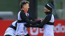 Pemain Liverpool Roberto Firmino (kiri) bercanda dengan Fabinho (kanan) saat sesi latihan tim di Pusat Pelatihan AXA, Liverpool, Inggris, 20 Februari 2023. Liverpool akan menghadapi pertandingan sepak bola leg pertama babak 16 besar Liga Champions UEFA melawan Real Madrid. (Lindsey Parnaby/AFP)