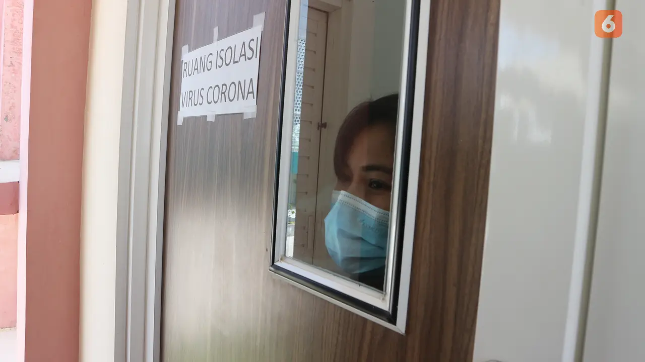 Seorang perawat mengintip dari jendela ruang isolasi yang disiapkan RSUD Undata Palu untuk pasien virus corona. Foto: Heri Susanto.