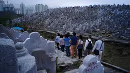 Orang-orang mengunjungi makam kerabat saat Festival Chung Yeung atau juga dikenal Tomb Sweeping Day di Hong Kong, 17 Oktober 2018. Pada saat festival, ribuan warga Hong Kong memberi penghormatan kepada leluhur mereka yang meninggal. (AP/Vincent Yu)