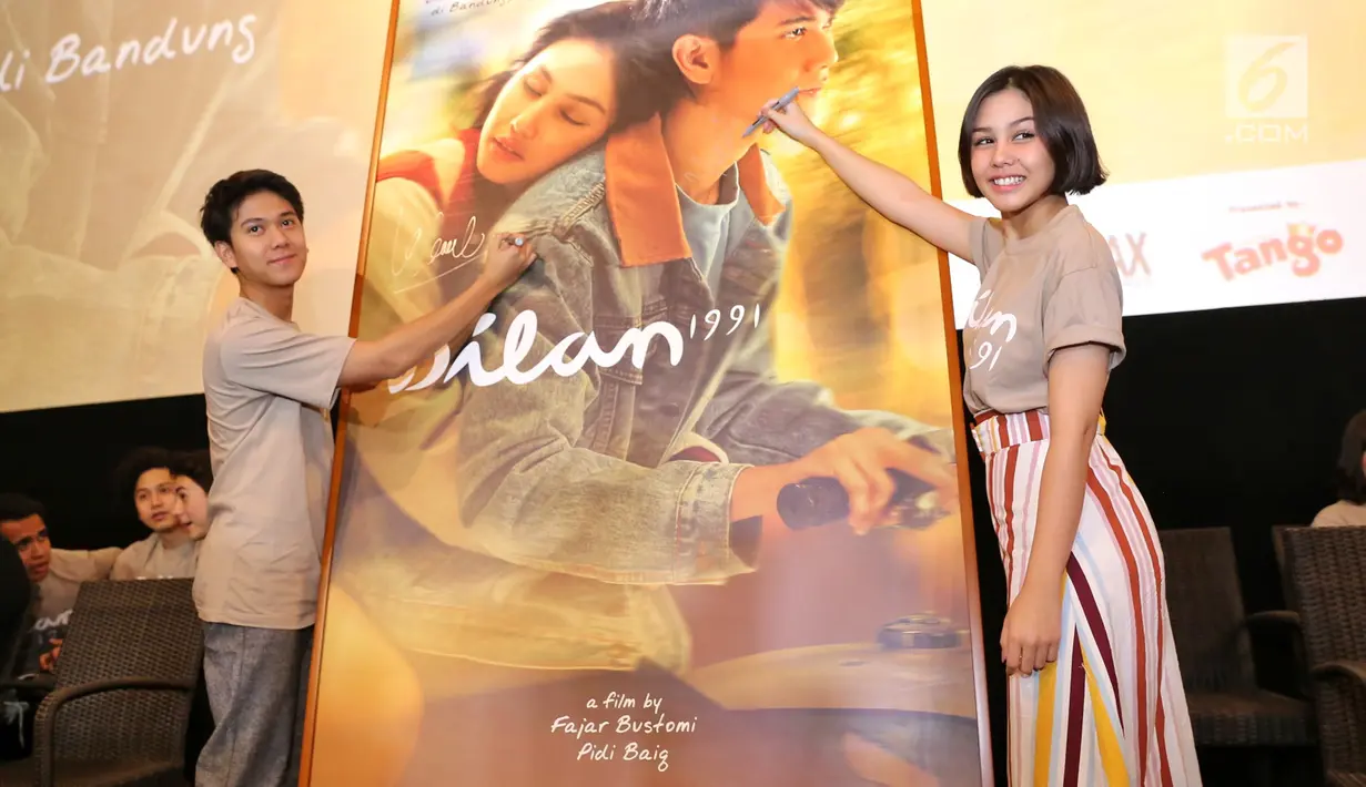 Pemeran film Dilan 1991, Vanesha Prescila dan Iqbaal Ramadhan menandatangani poster film di Kemang, Jakarta, Kamis (17/1). Film ini diharapkan kembali berkontribusi bagi kemajuan industri film nasional. (Kapanlagi.com/ Adrian Utama Putra)