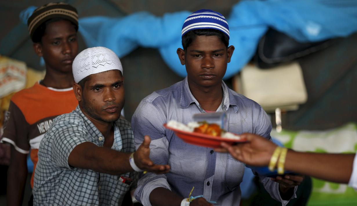 Para pengungsi etnis Rohingya saat menerima makanan di tempat penampungan, Kuala Langsa, Aceh (25/5/2015). Pemerinta RI mengalokasikan bantuan sebesar Rp 2,3 Miliar untuk pengungsi Rohingya yang berada di Aceh. (Reuters/Darren Whiteside)