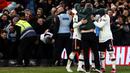 Setelah berhasil masuk lapangan, suporter tersebut melakukan selebrasi bersama ketiga pemain MU dengan memeluknya. (AFP/Darren Staples)