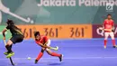 Atlet hoki Indonesia memukul bola saat bertanding melawan Jepang dalam babak penyisihan hoki putra Asian Games di Lapangan Hoki Gelora Bung Karno, Jakarta, Rabu (22/8). Indonesia kalah dengan skor 1-3. (Liputan6.com/Fery Pradolo)