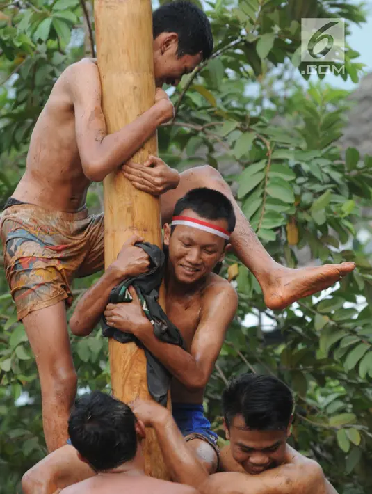 Sejumlah peserta berjibaku lumpur dan oli mengikuti lomba panjat pinang di Perumahan Griya Pamulang 2, Tangerang Selatan, Jumat (17/8). Lomba yang diselengarakan oleh Bina Remaja ini dalam rangka memeriahkan HUT Ke-73 RI. (Merdeka.com/Dwi narwoko)