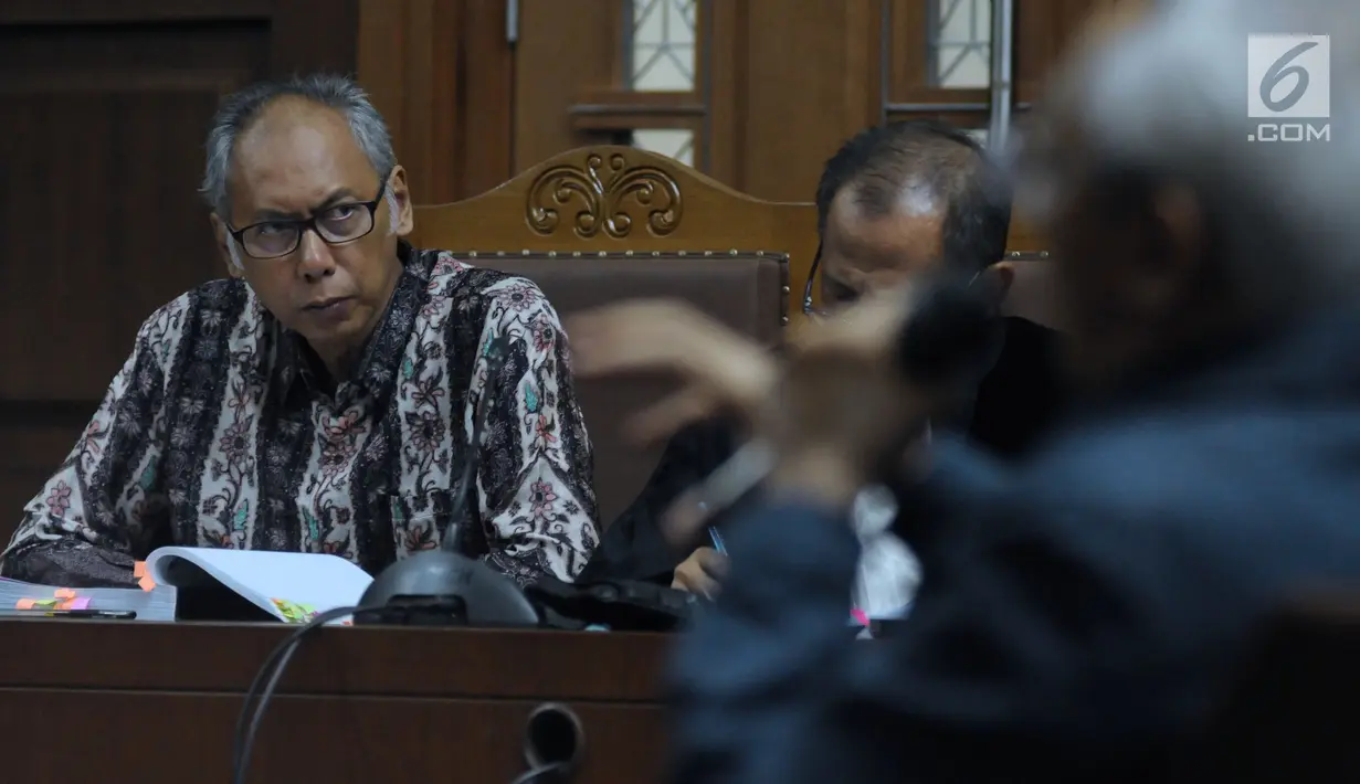 Terdakwa perkara merintangi penyidikan dugaan korupsi E-KTP, Bimanesh Sutarjo (kiri) menyimak keterangan saksi saat mengikuti sidang lanjutan di Pengadilan Tipikor, Jakarta, Senin (16/4). Sidang mendengar keterangan saksi.(Liputan6.com/Helmi Fithriansyah)