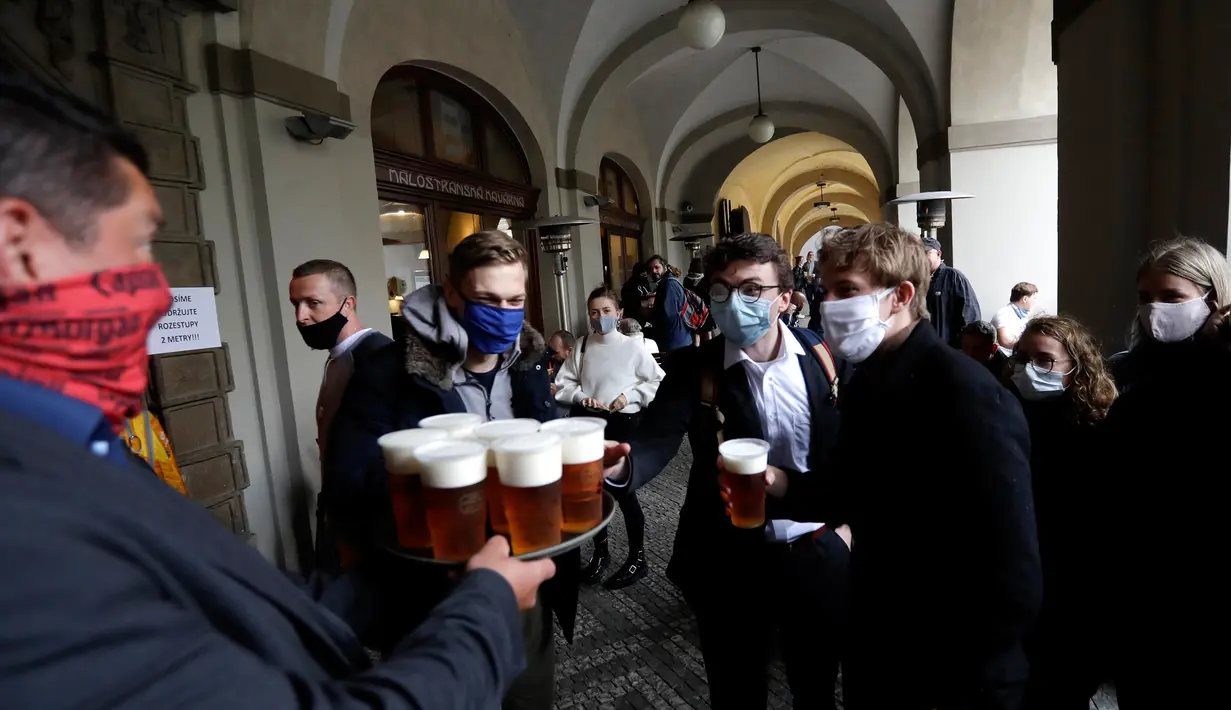 Orang-orang mengantre untuk minum bir di teras restoran di Praha, Republik Ceko, Senin, (11/5/2020). Republik Ceko mengambil langkah normal di tengah pandemi coronavirus dengan melonggarkan lebih banyak pembatasan yang diadopsi oleh pemerintah untuk menampungnya. (AP/Petr David Josek)