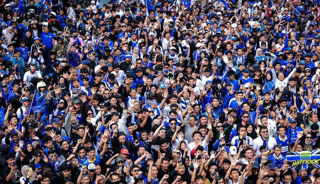 Warga menyambut tim dan ofisial Persib Bandung saat pawai perayaan gelar juara BRI Super League 2025/2026 di Bandung, Jawa Barat, Minggu (24/5/2026). (Bola.com/Bagaskara Lazuardi)