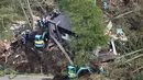 Tim penyelamat mencari orang hilang setelah gempa dan tanah longsor terjadi di Kota Atsuma, Prefektur Hokkaido, Jepang, Kamis (6/9). PM Shinzo Abe mengatakan 25 ribu tentara dan personel lainnya dikirim untuk penyelamatan. (Kyodo News via AP)