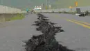 Retakan terlihat di sepanjang jalan di dekat jembatan Kaoliao yang runtuh di wilayah Hualien Taiwan timur (19/9/2022). Gempa bermagnitudo 6,9 mengguncang Kabupaten Hualien, Taiwan, pada Minggu pukul 14.44 waktu setempat (13.44 WIB). (AFP/Sam Yeh)