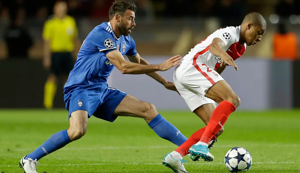 Penyerang AS Monaco, Kylian Mbappe berusaha membawa bola dari kawalan bek Juventus, Andrea Barzagli di leg pertama semifinal Liga Champions di stadion Louis II, Monaco (4/5). Juventus menang atas tuan rumah Monaco dengan skor 2-0. (AP Photo/Claude Paris)
