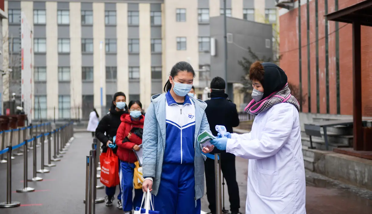 Para murid berbaris untuk melakukan pemeriksaan suhu tubuh di Sekolah Menengah Pertama No. 87 di Changchun, Provinsi Jilin, China timur laut, (20/4/2020). Lebih dari 56.000 pelajar tahun akhir sekolah menengah pertama di Changchun kembali masuk sekolah pada Senin (20/4). (Xinhua/Yan Linyun)