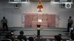 Penyerahan uang ini sebagai bagian dari upaya pemulihan aset negara dan mengembalikan kerugian yang dialami oleh perusahaan dana pensiun Pegawai Negeri Sipil (PNS) tersebut. Tampak dalam foto, polisi berjaga di sisi kiri dan kanan tumpukan uang sebesar Rp 300 miliar dipamerkan di gedung Merah Putih Komisi Pemberantasan Korupsi (KPK), Jakarta, Kamis (20/11/2025). (Liputan6.com/Helmi Fithriansyah)