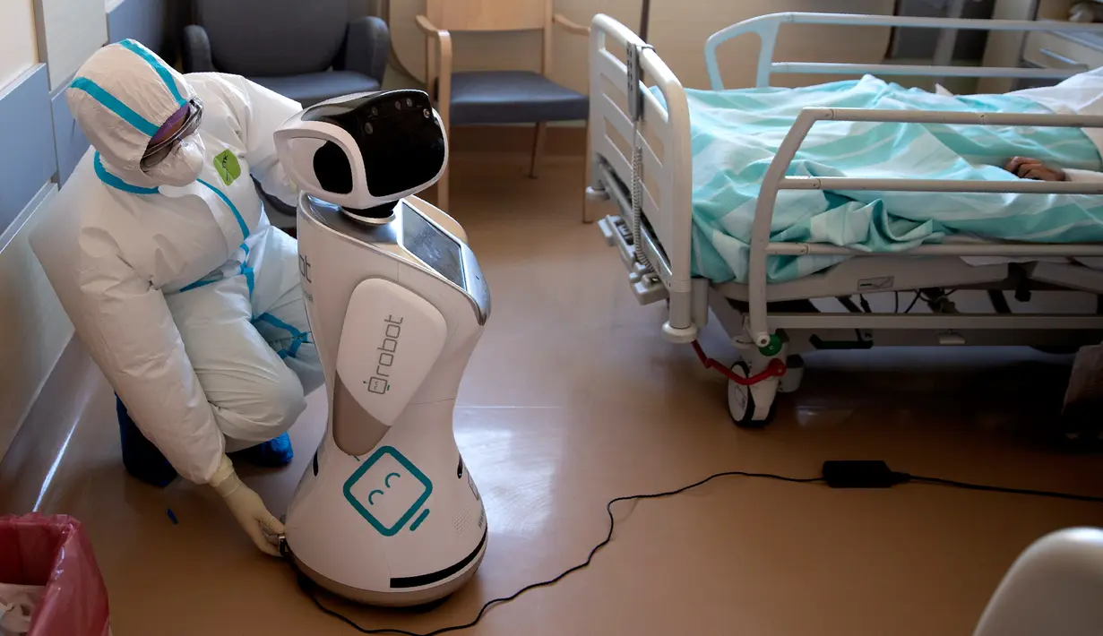 Wakil kepala unit perawatan intensif Flavio Tangian, menyiapkan robot di rumah sakit 'Ospedale di Circolo', di Varese, Italia, 8 April 2020. Sebanyak enam unit robot yang berjalan di atas roda ini membantu kinerja staf medis dalam merawat pasien virus corona Covid-19. (AP/Luca Bruno)
