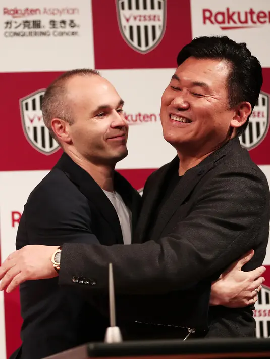 Mantan pemain Barcelona, Andres Iniesta (kiri) berpelukan dengan pemilik klub Vissel Kobe, Hiroshi Mikitani saat konferensi pers di Tokyo, Jepang, Kamis (24/5). Iniesta resmi bergabung dengan Vissel Kobe. (Behrouz MEHRI/AFP)