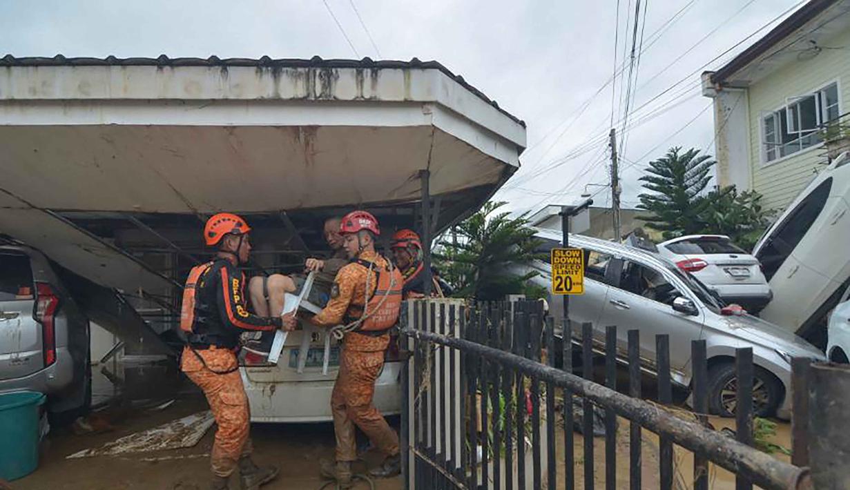 Tim penyelamat mengevakuasi seorang warga dari rumahnya yang terendam banjir menyusul hujan deras yang dibawa oleh Topan Kalmaegi di sebuah permukiman di Kota Cebu, Filipina tengah, pada Selasa 4 November 2025. Badan cuaca Filipina memperkirakan Topan Kalmaegi—badai tropis ke-20 tahun ini—akan bergerak ke arah Laut China Selatan pada Selasa (4/11) malam atau Rabu (5/11/2025) pagi waktu setempat. (Alan TANGCAWAN/AFP)