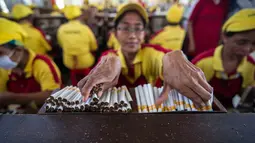 Pekerja merapikan batangan rokok yang telah selesai dibuat di PT Hanjaya Mandala Sampoerna (HMSP)Tbk, Surabaya, Kamis (19/5). HMSP mendapat rekor MURI dengan kecelakaan kerja nihil selama 20 tahun (1996-2006). (AFP Photo/Juni Kriswanto)