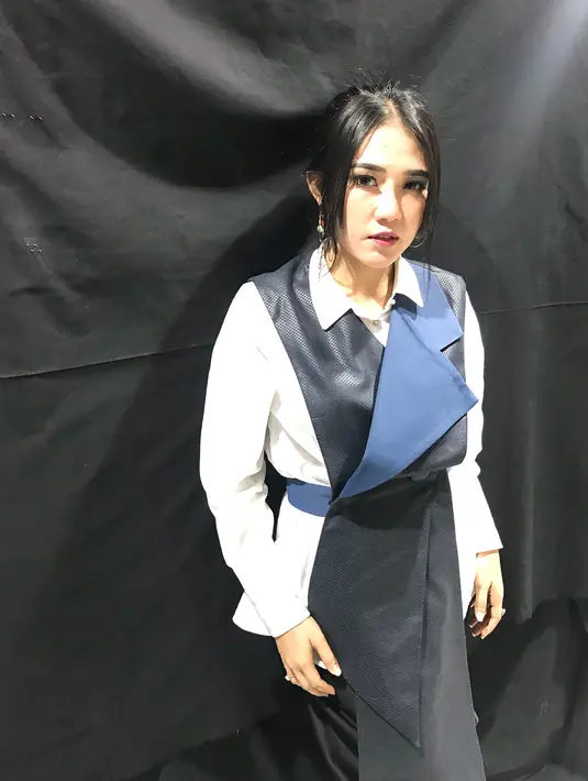 Baju yang berpotongan unik dan berjerah kemeja ini membuat penampilan Via sangat menarik meski simple. Terlebih tatanan rambutnya hanya diikat satu rendah dengan menyisakan poni bagian depan. (Instagram/viavallen)