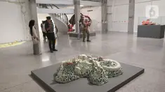 Pengunjung memperhatikan pameran foto dan instlalasi di Galeri ROH, Jakarta, Jumat (22/11/2024). (Liputan6.com/Herman Zakharia)