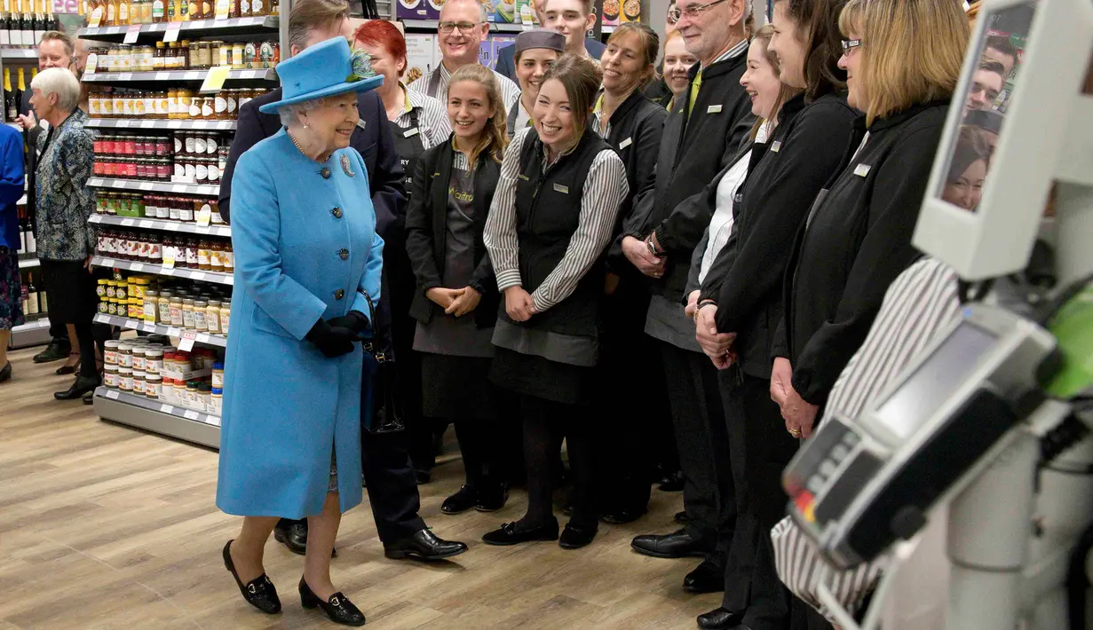 Ratu Elizabeth II menyapa para karyawan pasar swalayan Waitrose pada kunjungannya ke kota Poundbury, Inggris (27/10). Ratu Inggris ini datang ke Poundbury juga untuk meresmikan patung ibundanya. (Reuters/Justin Tallis)