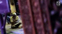 Seorang umat Islam membaca Al-Quran di Masjid At Tin, Jakarta, Selasa (14/7). Bulan suci Ramadan dimanfaatkan umat muslim untuk mendekatkan diri kepada Allah SWT dengan meningkatkan ibadah di masjid. (Liputan6.com/Helmi Fithriansyah)
