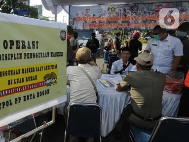 Petugas gabungan mendata warga yang tidak mengenakan masker saat Operasi Masker Gabungan di Perempatan Ciawi, Bogor, Kamis (10/9/2020). Razia masker yang dilakukan Pemkot dan Pemkab Bogor ini menyasar warga yang tidak mengenakan masker dengan denda sebesar Rp 100.000. (merdeka.com/Arie Basuki)