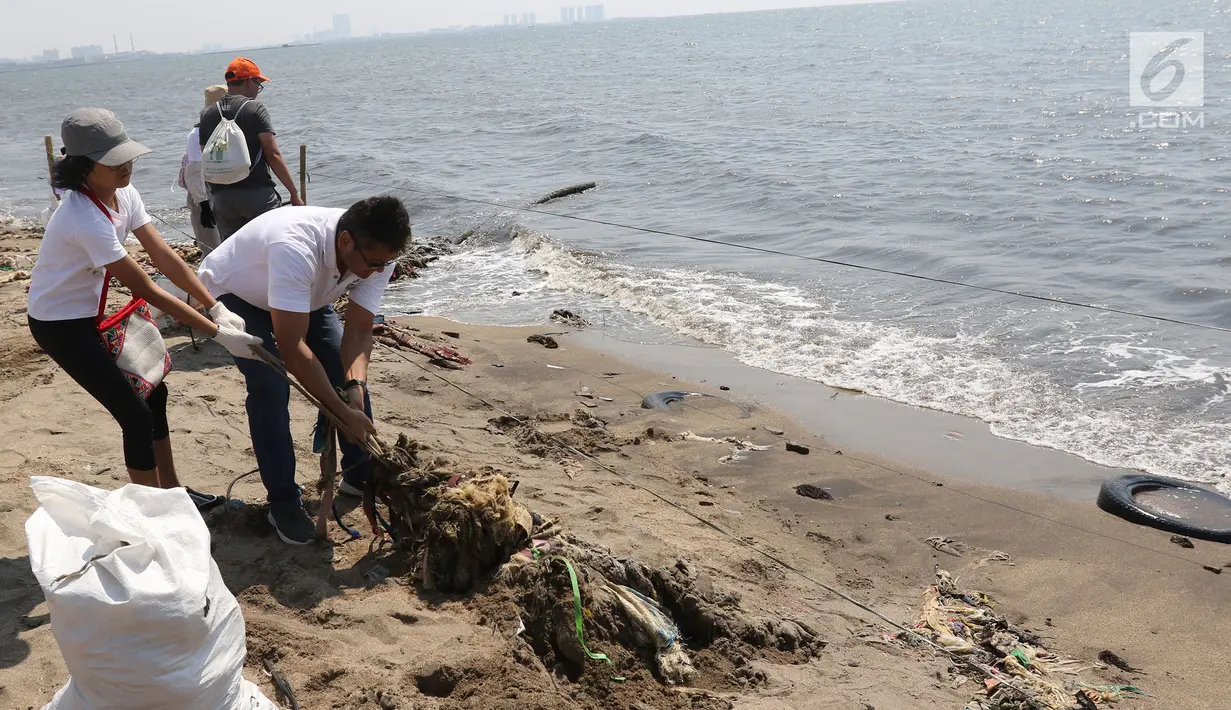 Para relawan membersihkan sampah di pantai timur ancol, Jakarta, Minggu (18/8/2019). Gerakan Menghadap Laut 2.0 akan digelar serentak di lebih dari 100 titik lokasi di seluruh Indonesia. (Liputan6.com/Herman Zakharia)