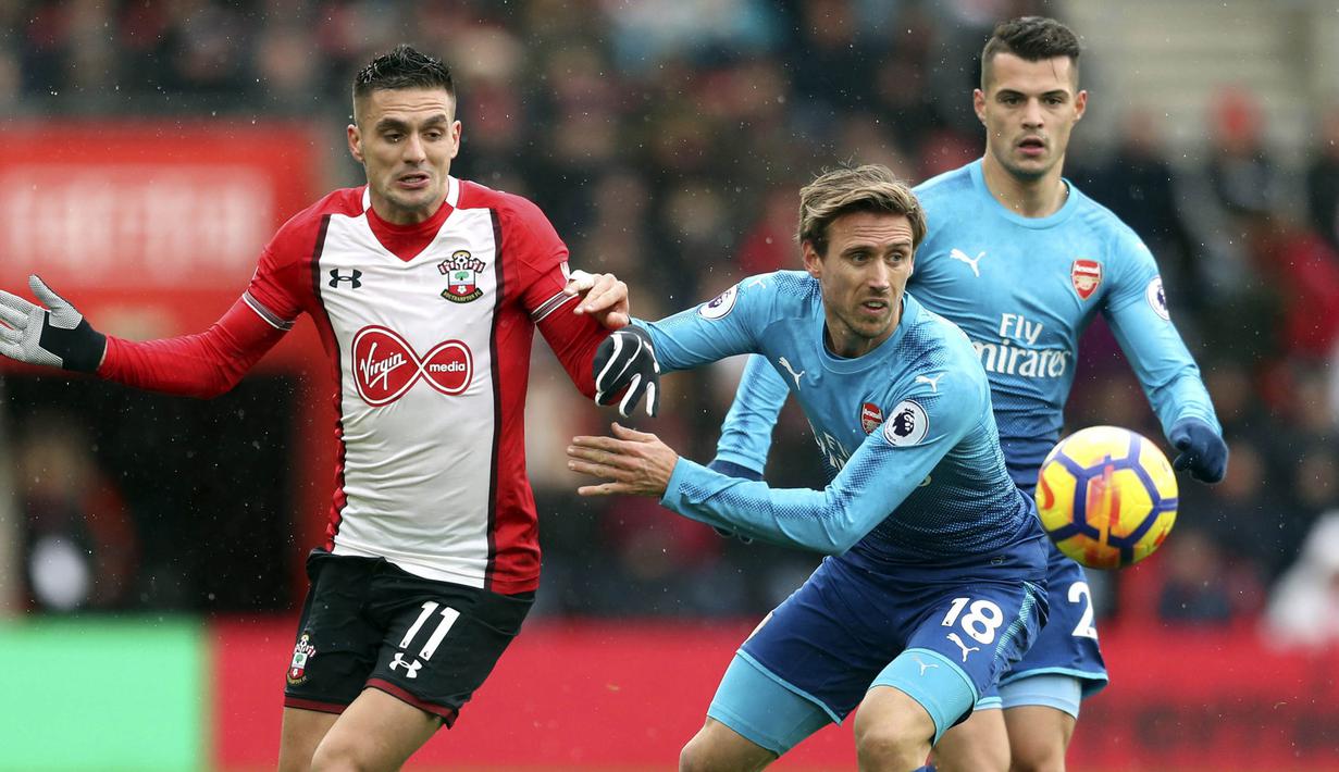 Bek Arsenal, Nacho Monreal, berebut bola dengan gelandang Southampton, Dusan Tadic, pada laga Premier League di Stadion St Mary's, Minggu (10/12/2017). Arsenal bermain imbang 1-1 dengan Southampton. (AP/Adam Davy)
