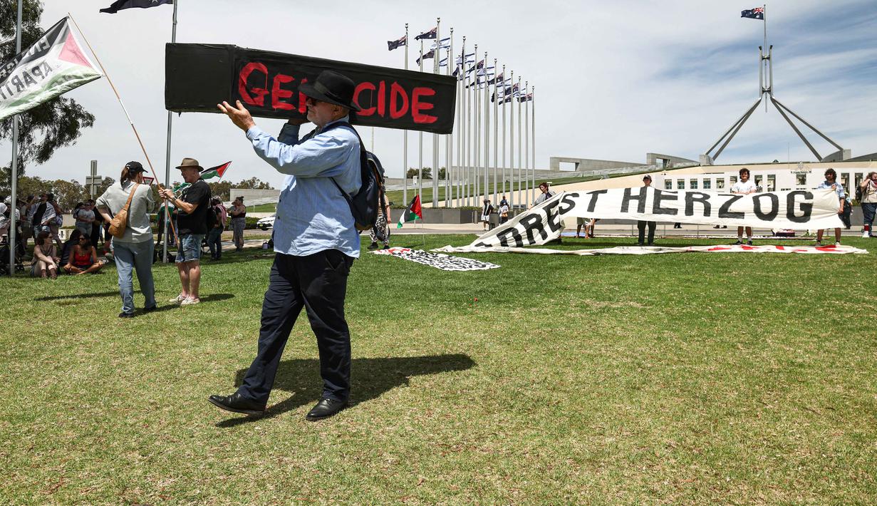 Diketahui, Isaac Herzog, berkunjung ke Australia atas undangan Perdana Menteri Anthony Albanese dan komunitas Yahudi setempat. Tampak dalam foto, seorang demonstran membawa peti mati tiruan saat para demonstran berkumpul di luar Gedung Parlemen menjelang pertemuan antara Perdana Menteri Australia Anthony Albanese dan Presiden Israel Isaac Herzog di Canberra pada Rabu 11 Februari 2026. (David GRAY/AFP)